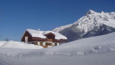 Hiking trail with view of the house in deep snow