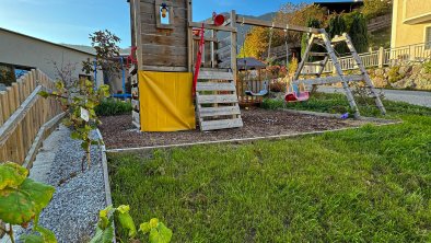 play ground with a slide, swing, climbing tower, and hiding spot, © Kathrin Huber