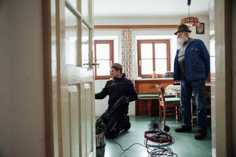 Chimney sweep Simon Hen&ouml;kl inspects the heating in the home of Alfred Larcher.