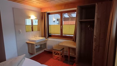 Doppelzimmer mit Waschbecken und Schrank