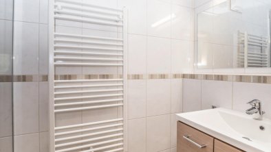 Small bathroom with shower and washing basin.