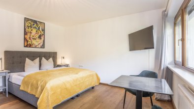 Spacious bedroom with table and cozy stools.