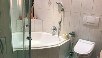 Badezimmer mit Badewanne und Dampfdusche