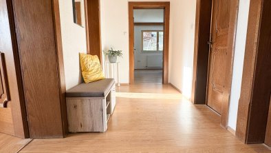 Entrance area with coat hooks, mirror, and a bench, © Kathrin Huber