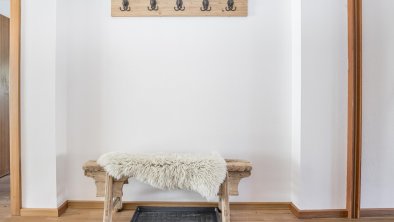 Coat rack with a cozy bench.