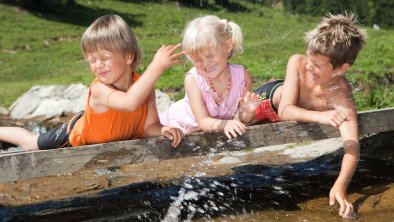 kinder-plantschen-am-wasser-im-brixental