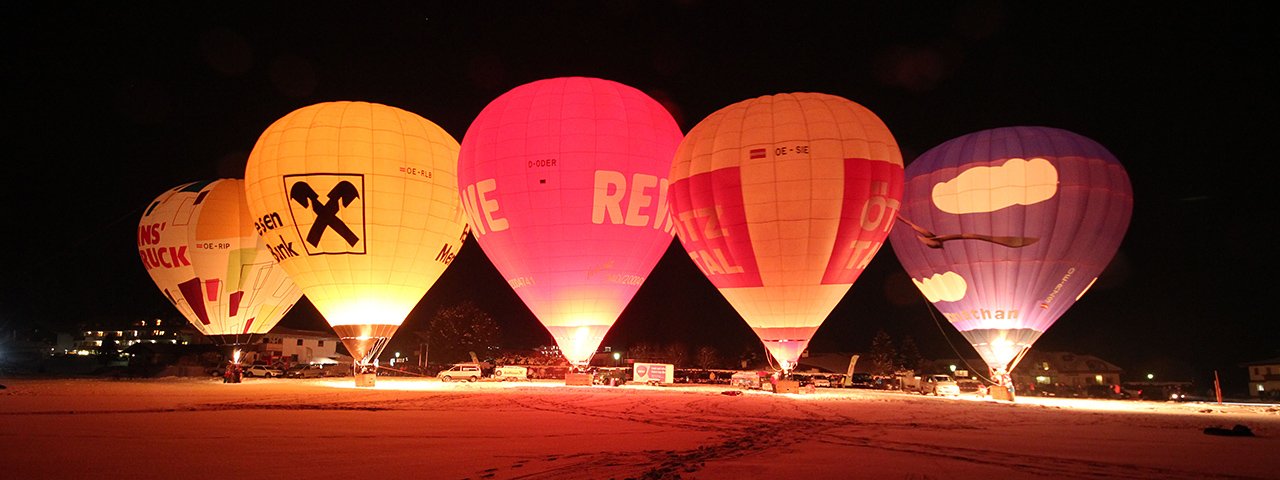 Rows of bulbous luminaries, dozens of feet tall, lit up from the glow of flames: The Night Glow during the Achensee International Balloon Days, © Stephanie Vetter / Achensee Tourismus