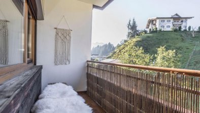 Balcony with a bench and garden view.