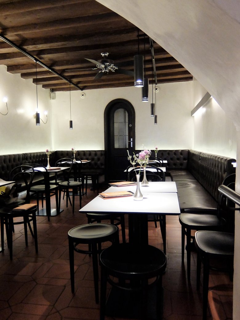 The inside of the Café is reminiscent of an elegant wine cellar, complete with stone walls and a rounded ceiling.