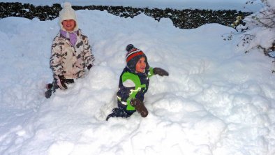 Kinderspaß im tief verschneiten Garten